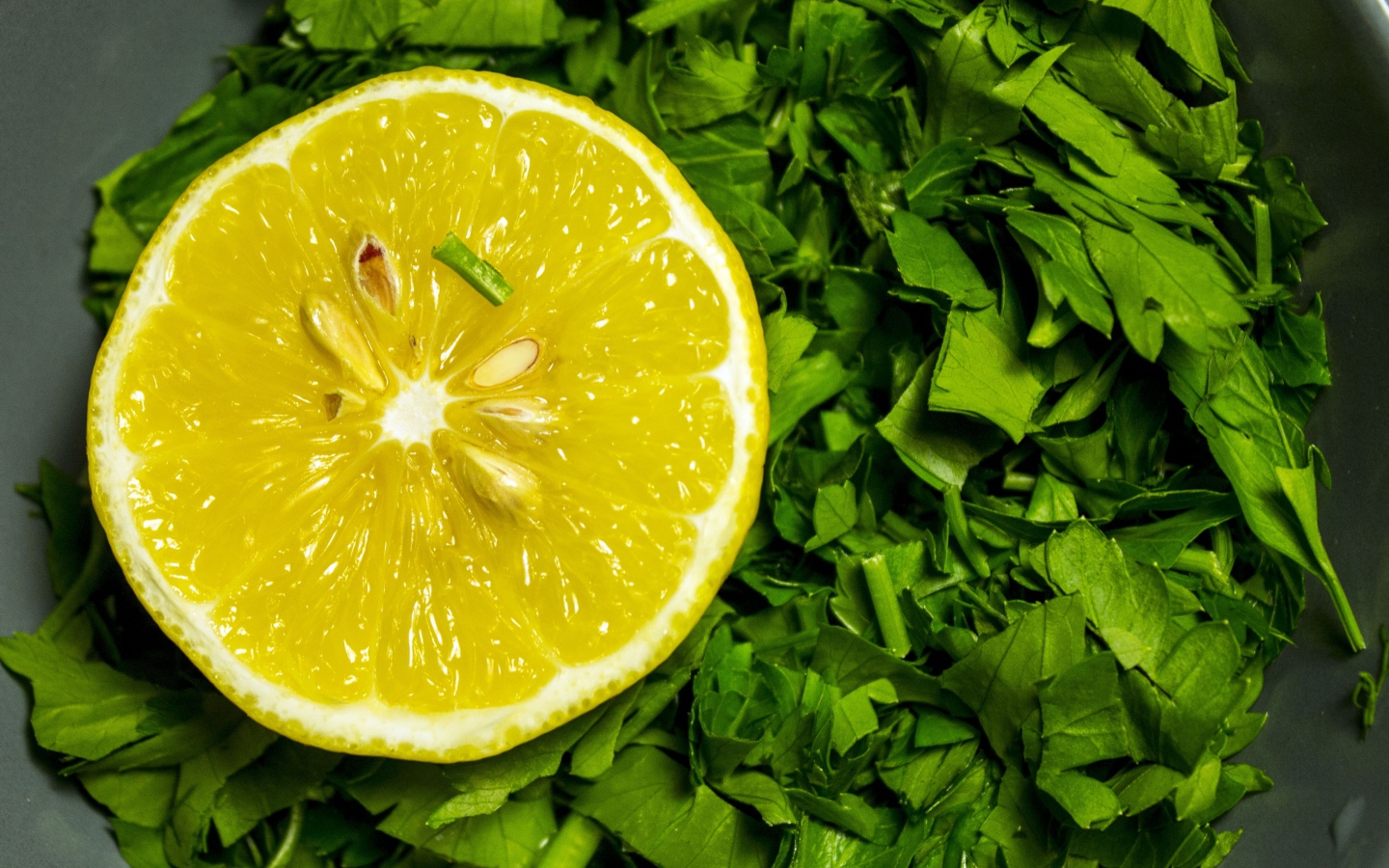 Половина желтого лимона с зеленью петрушки