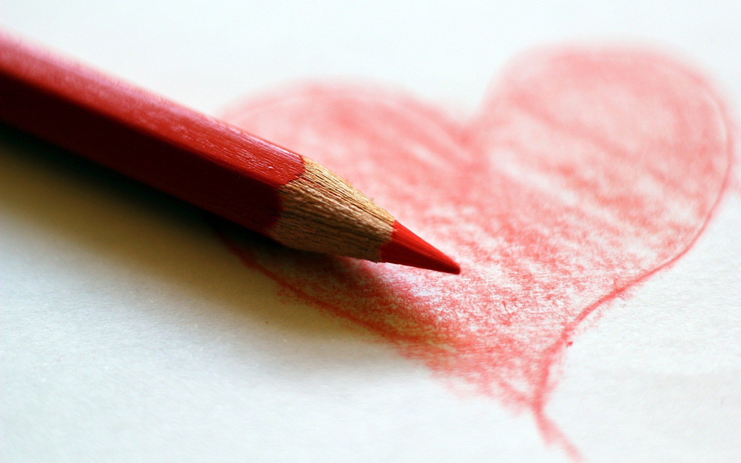 Нарисованное карандашом красное сердце на бумаге