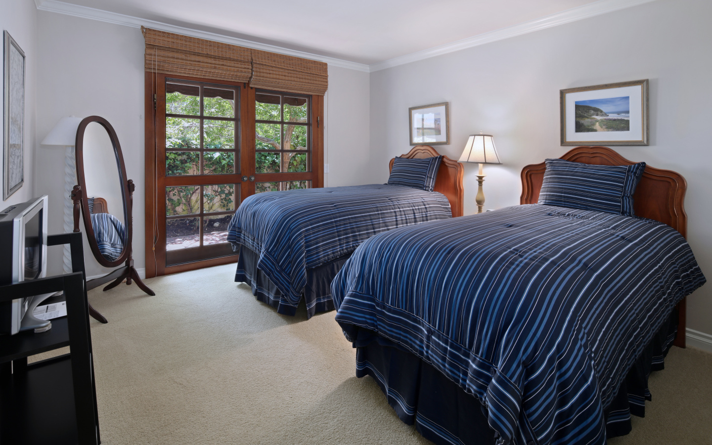 Две большие кровати в спальне с деревянным окном