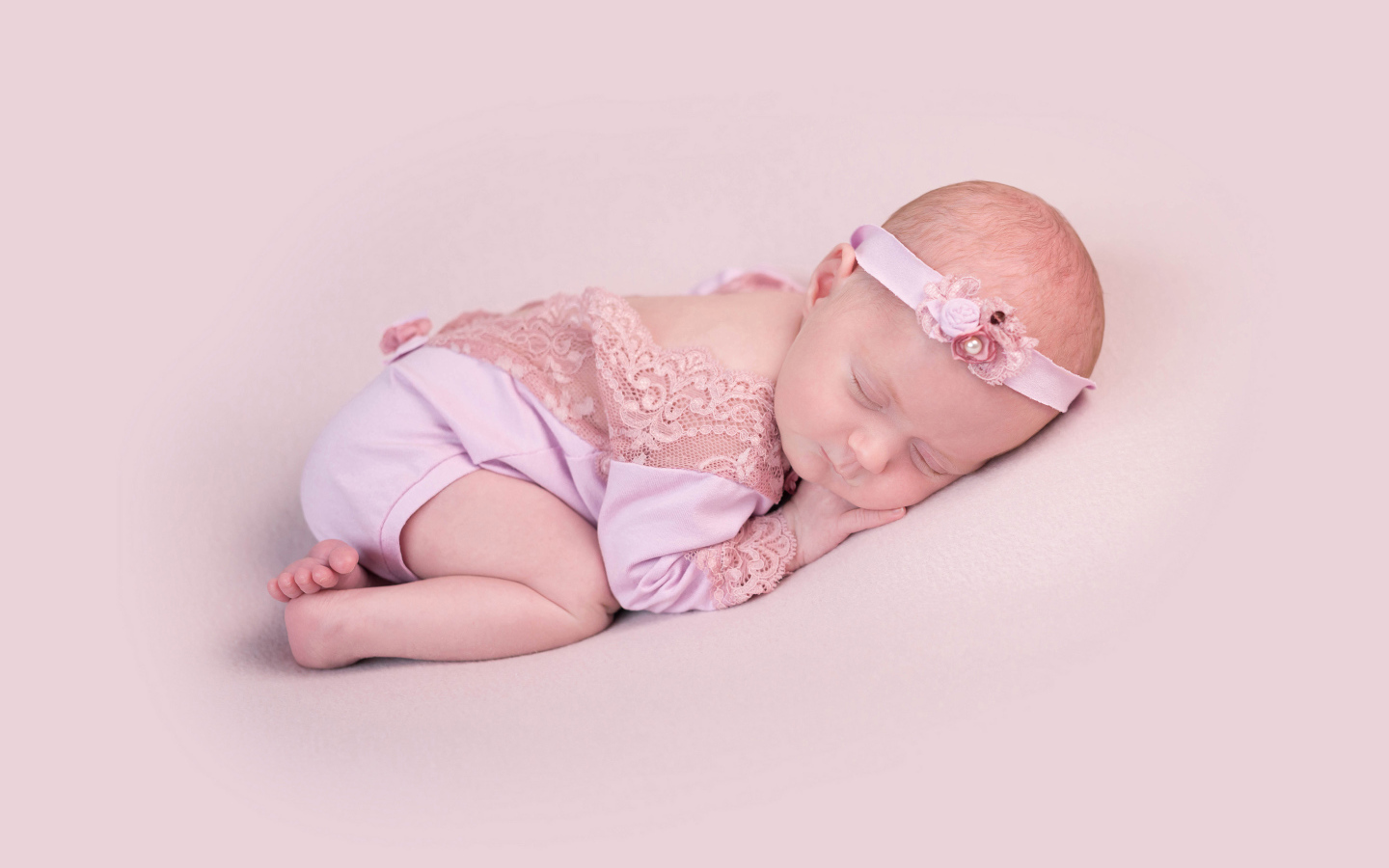Спящий грудной ребенок на розовом фоне