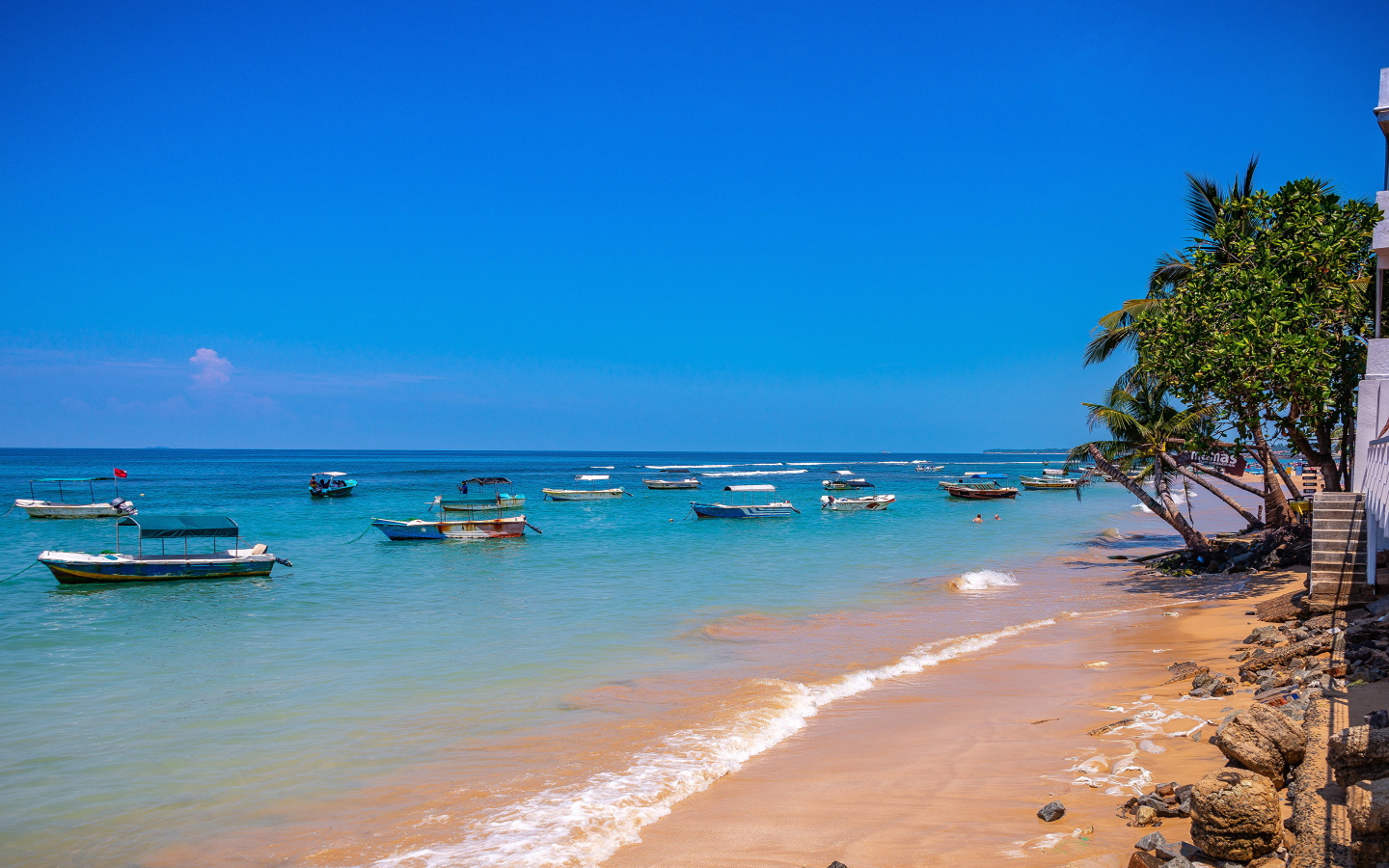 Лодки на берегу тропического пляжа на фоне голубого неба 