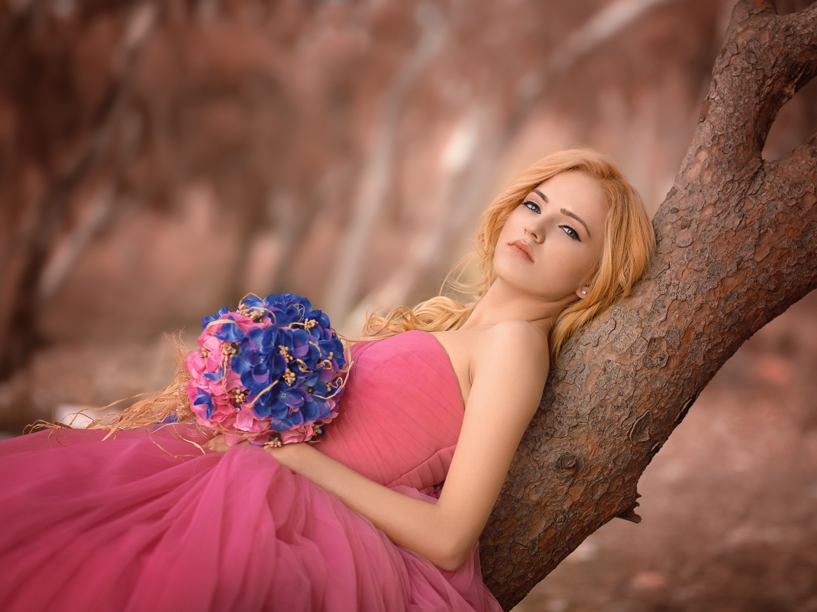 Красивая девушка в розовом платье с букетом 