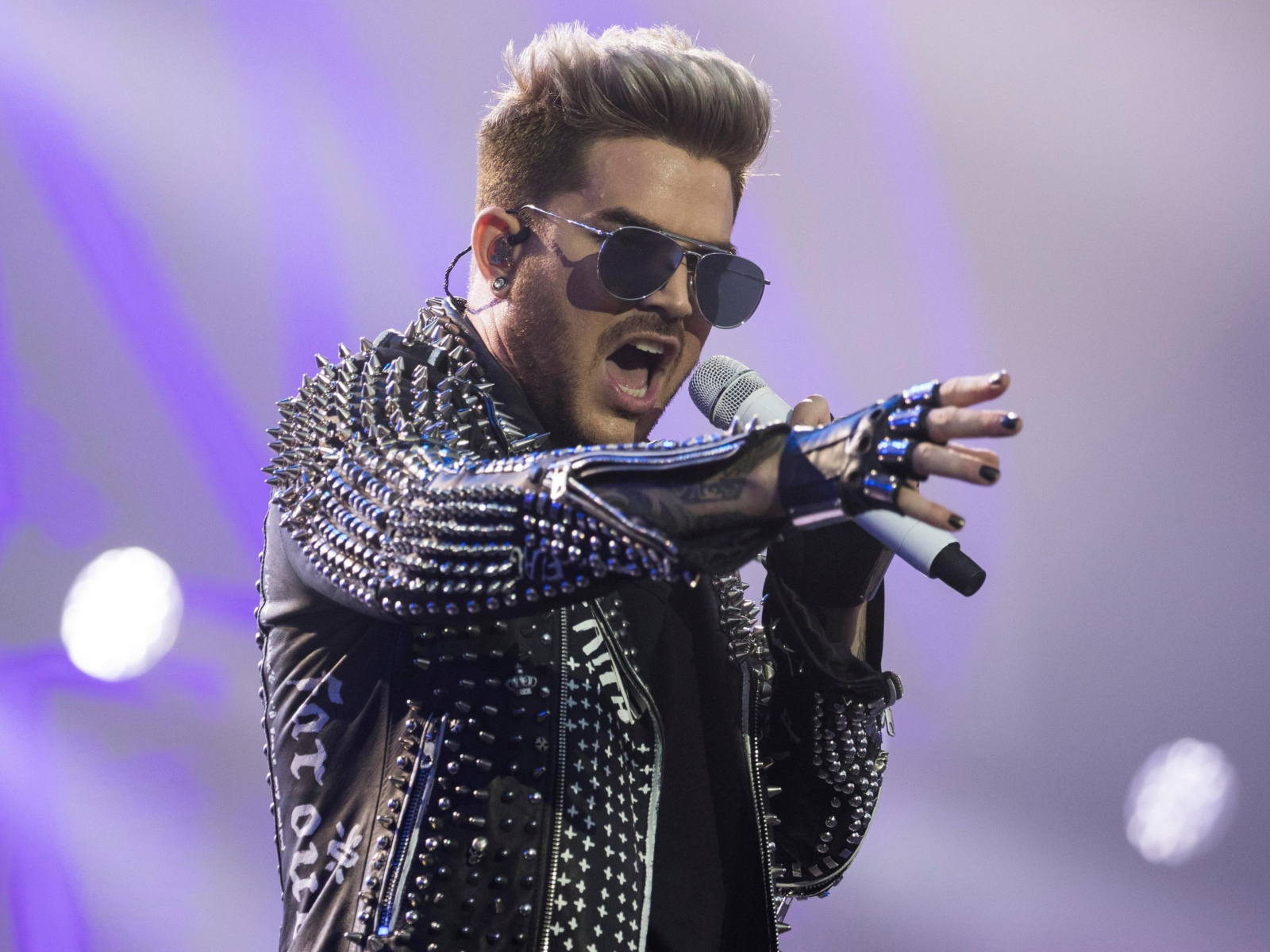 American singer Adam Lambert on stage with a microphone