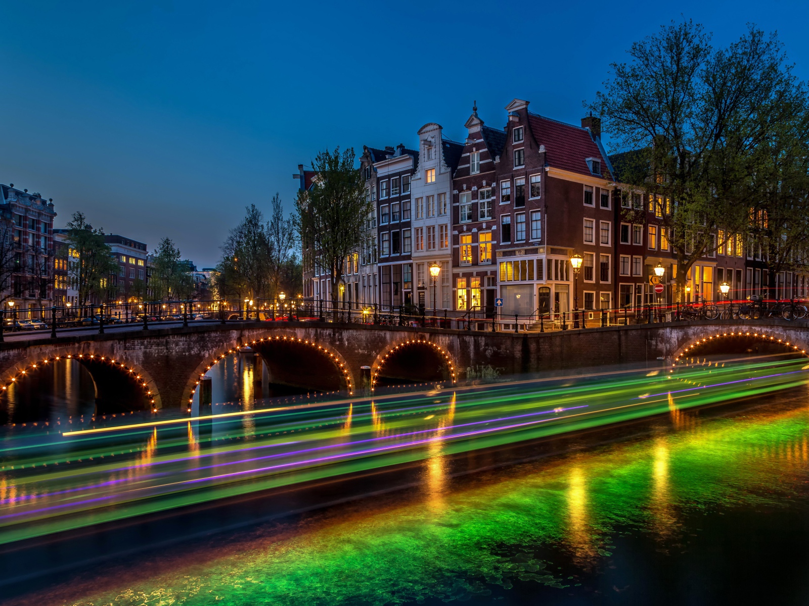 Мост и вечерние здания в городе Амстердам, Нидерланды 