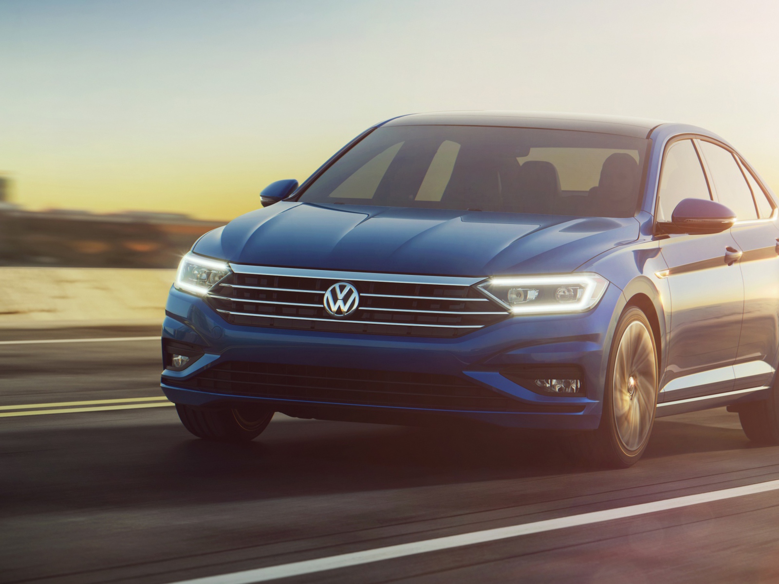 Синий автомобиль Volkswagen Jetta, 2019 на трассе