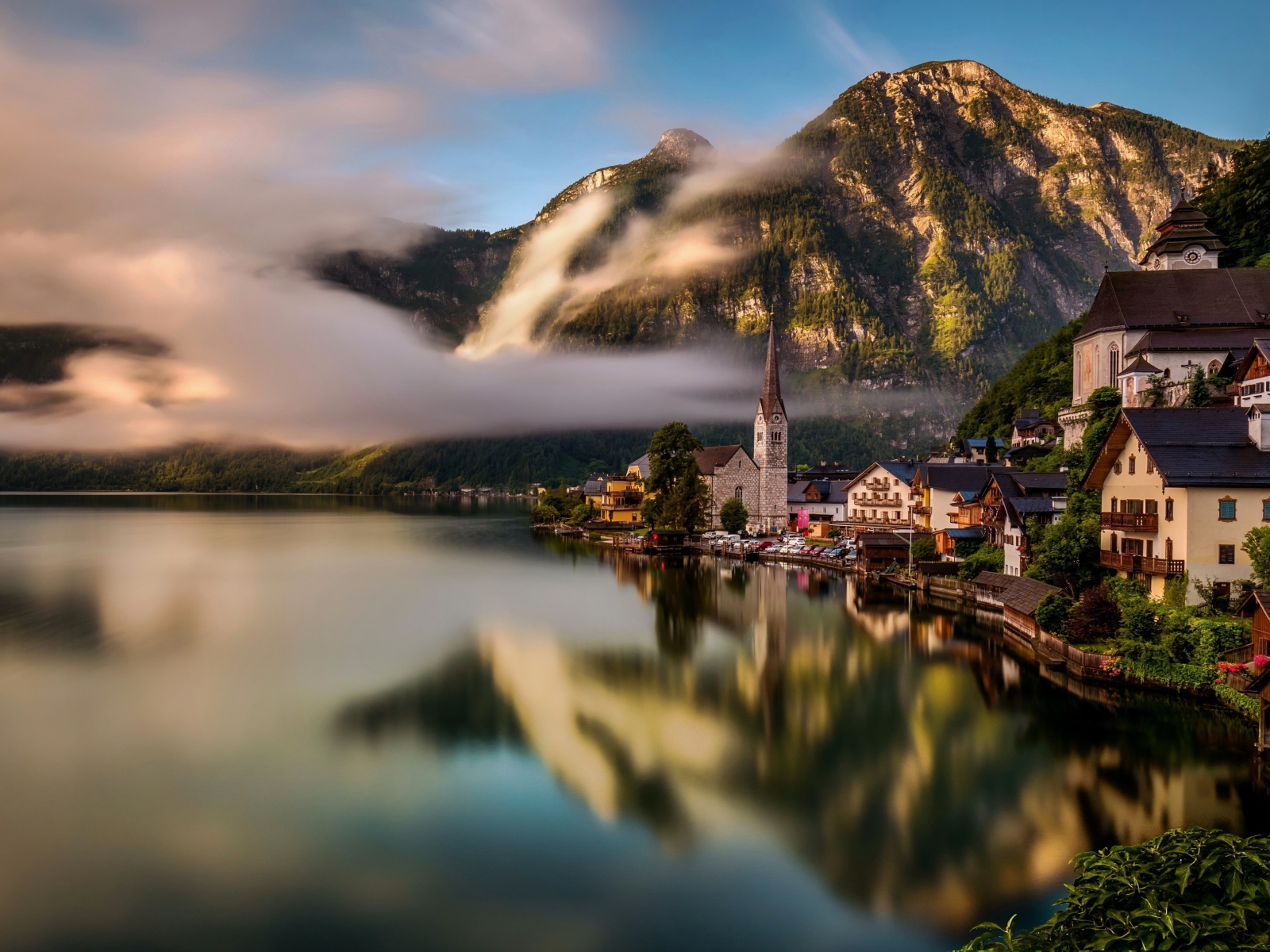City of Hallstatt over the misty lake in the Alps, Austria