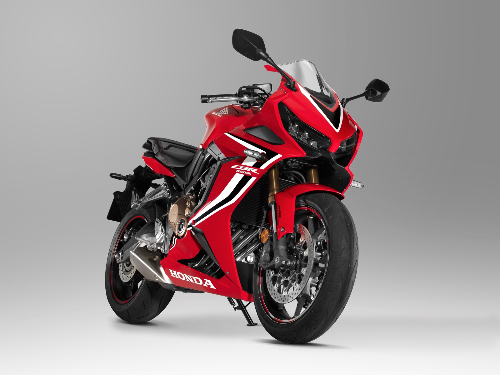 Красный мотоцикл Honda CBR 650 RR, 2021 года на сером фоне