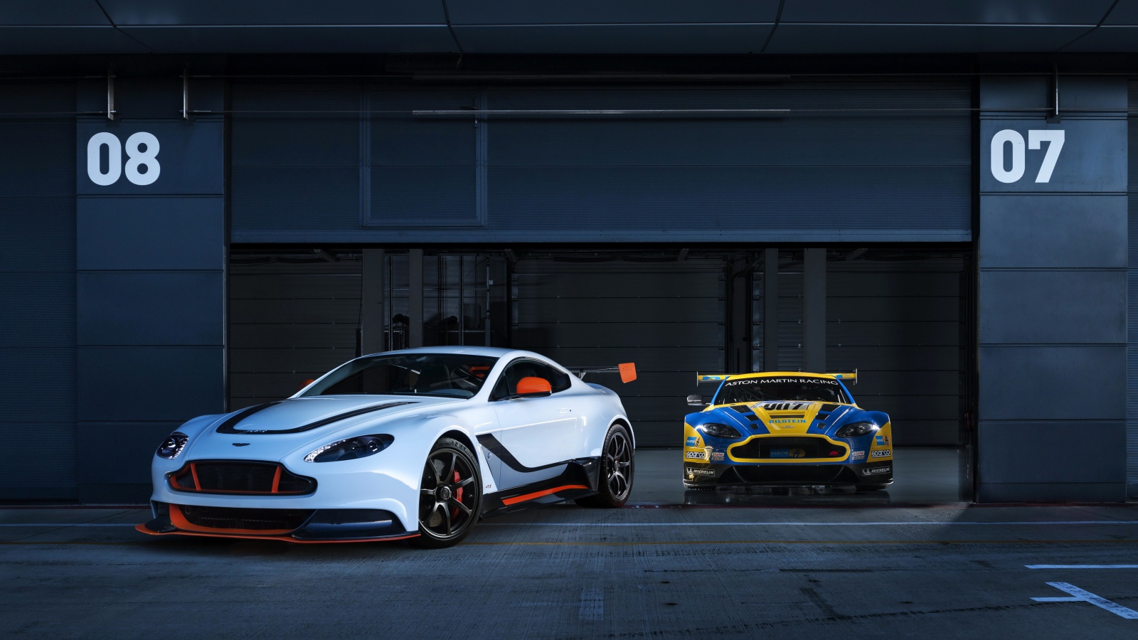 Два авто Aston Martin выезжают из гаража