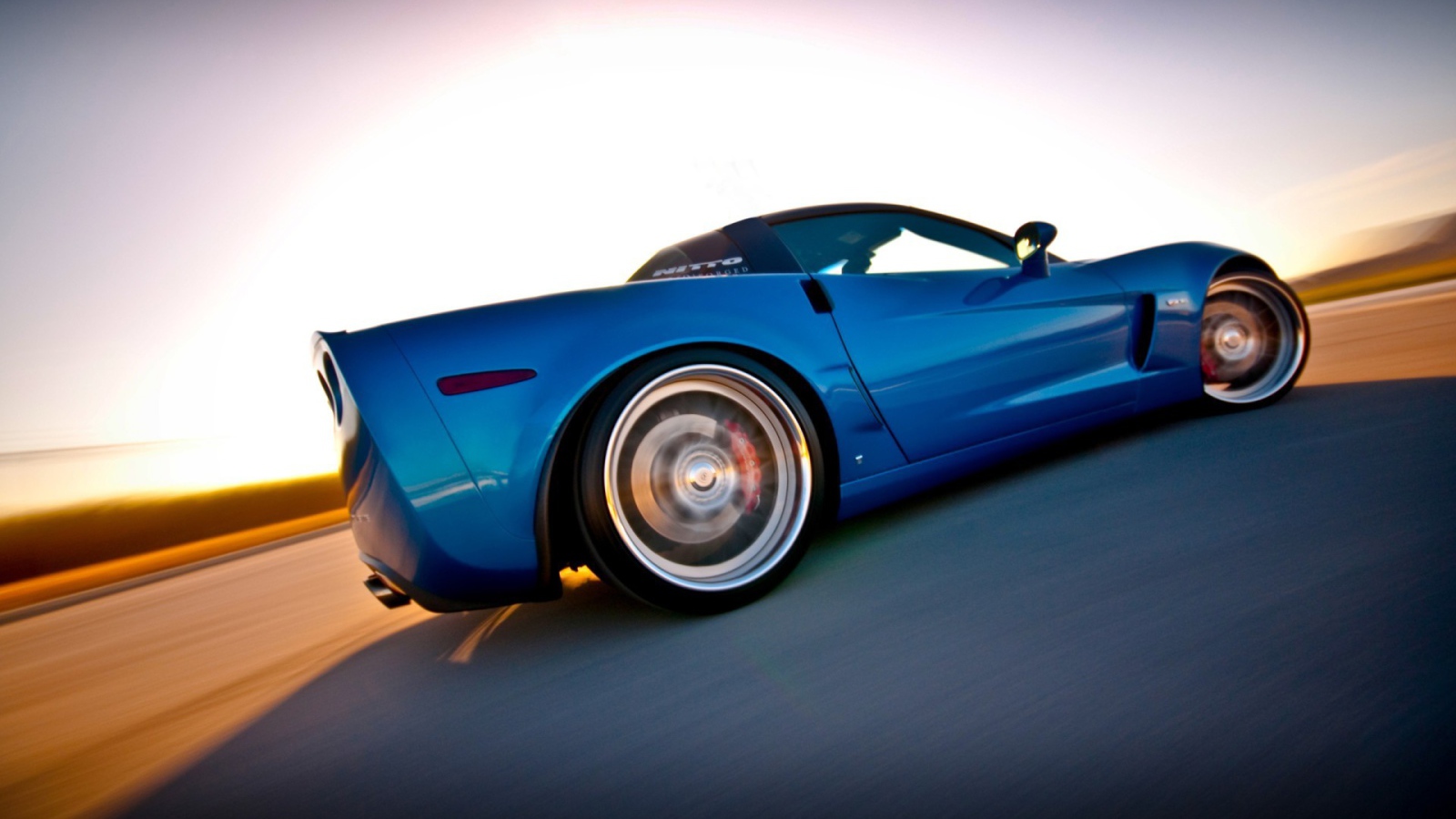 Синий Chevrolet Corvette быстро едет по пустыне