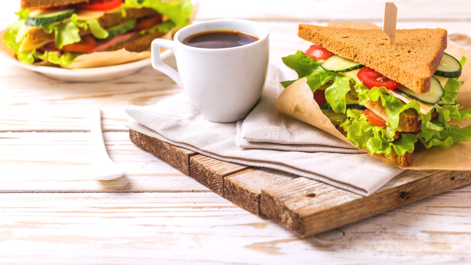Сэндвич на столе с чашкой кофе на завтрак