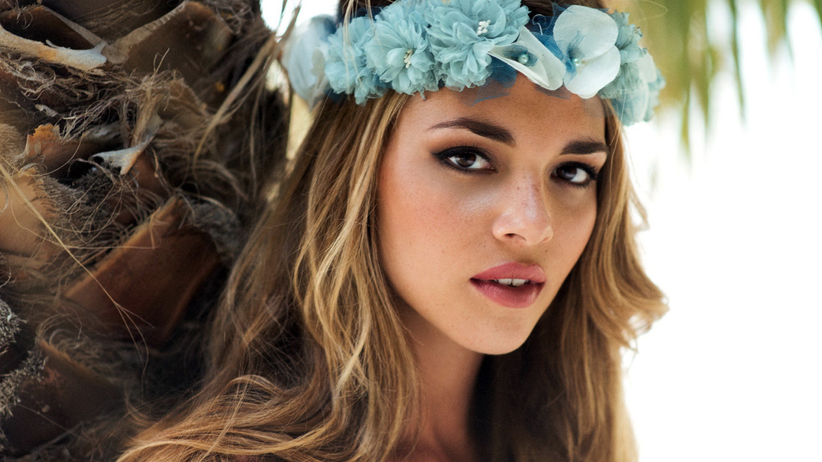Молодая девушка модель с венком из голубых цветов на голове 