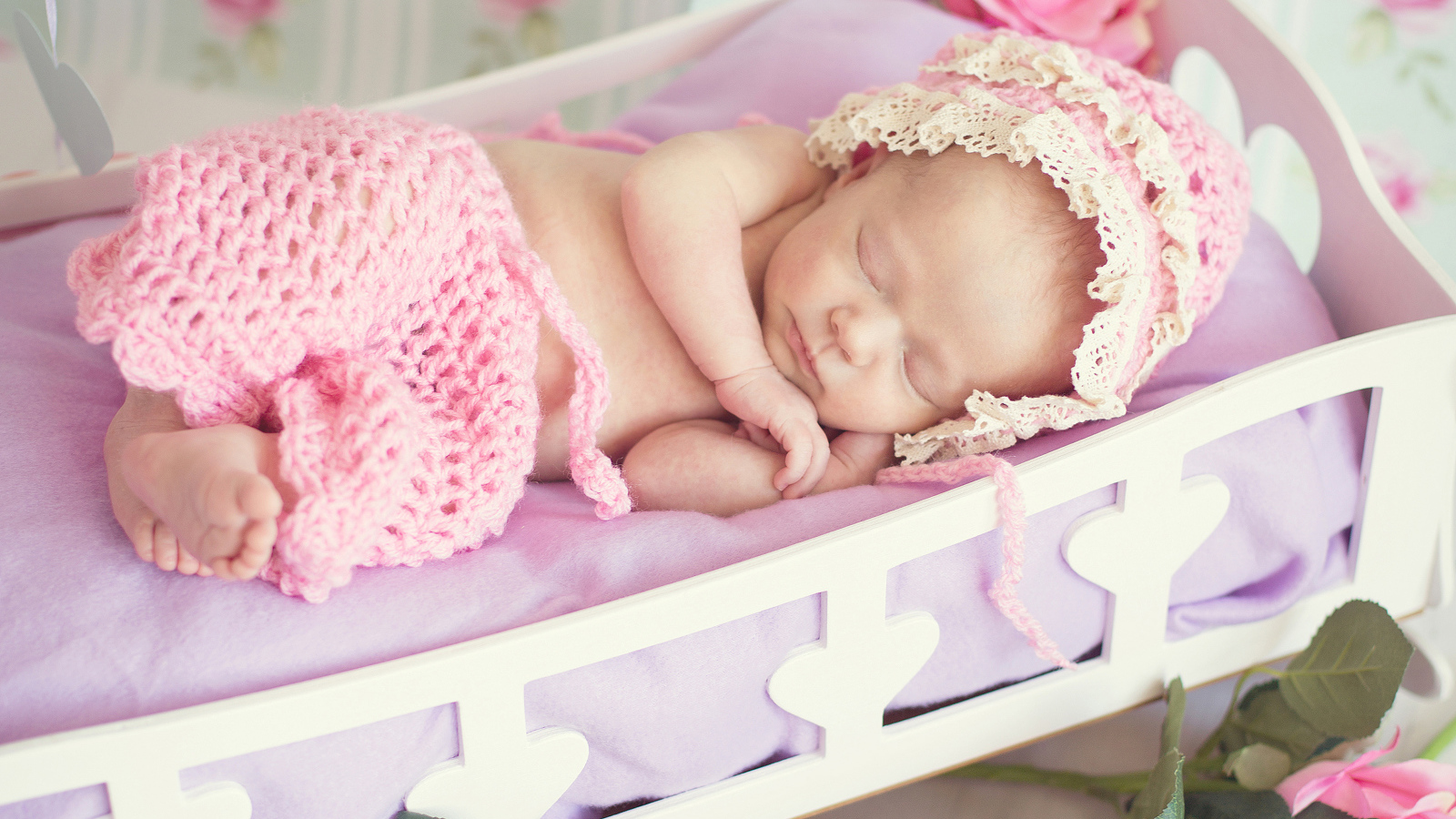 Милая спящая маленькая девочка в розовой кроватке