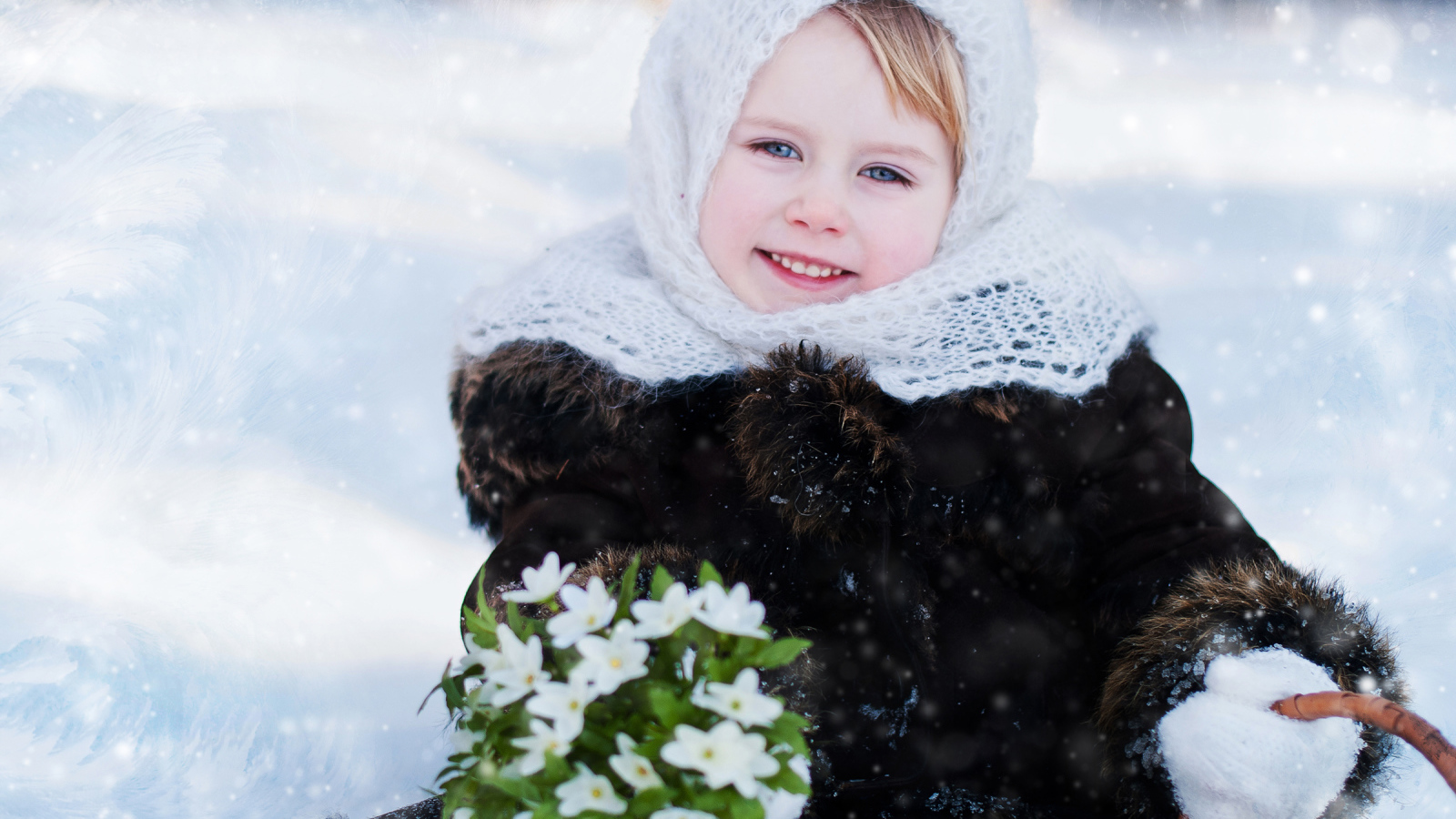 Маленькая голубоглазая девочка с букетом подснежников зимой