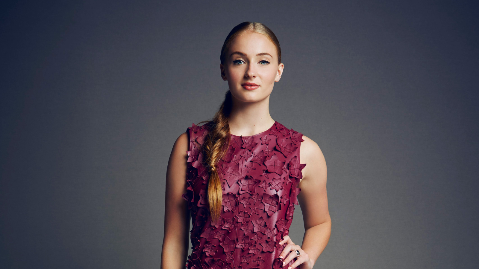 Actress Sophie Turner in a beautiful dress on a gray background