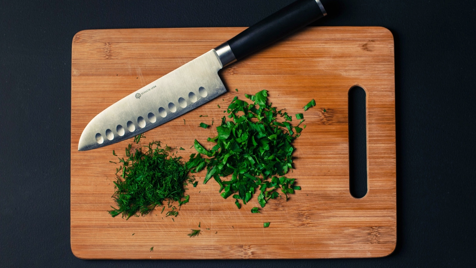 Нарезанная зелень на доске с ножом
