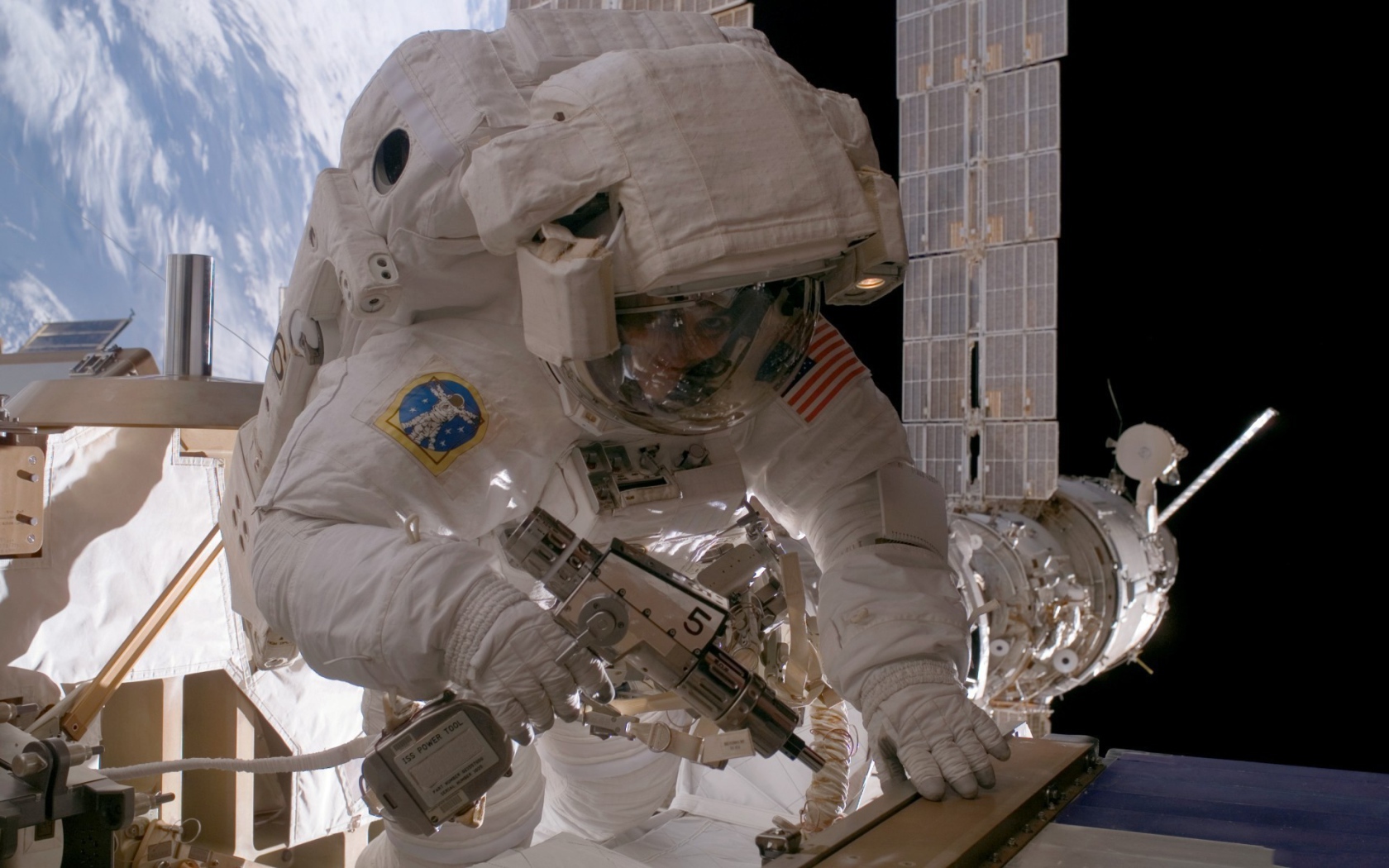 Космонавт на орбите выполняет ремонт
