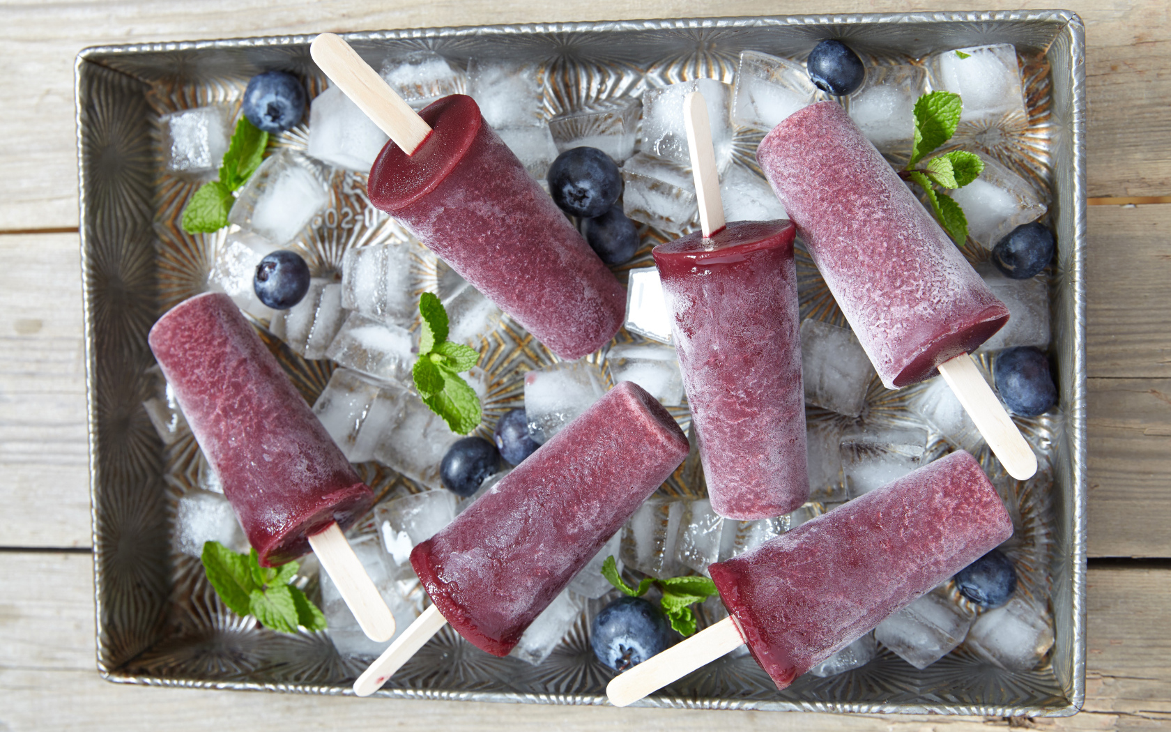 Delicious blueberry ice cream on a stick in an ice tray