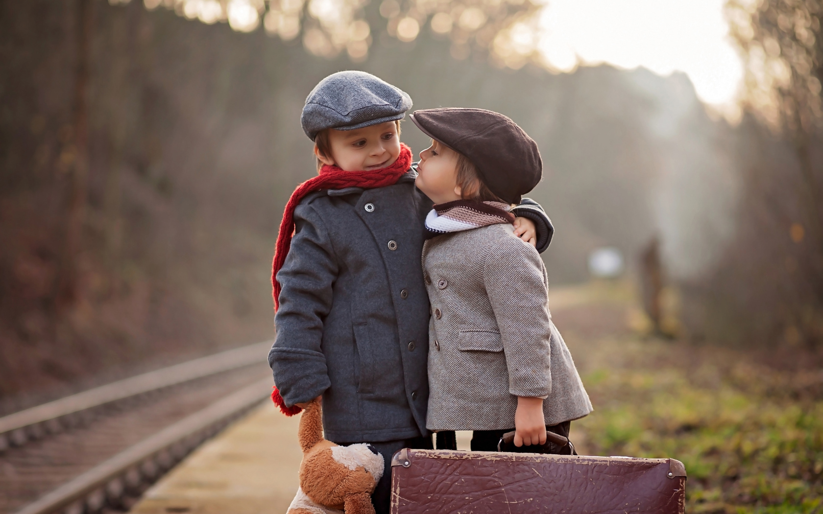 Два мальчика с большим чемоданом у железной дороги