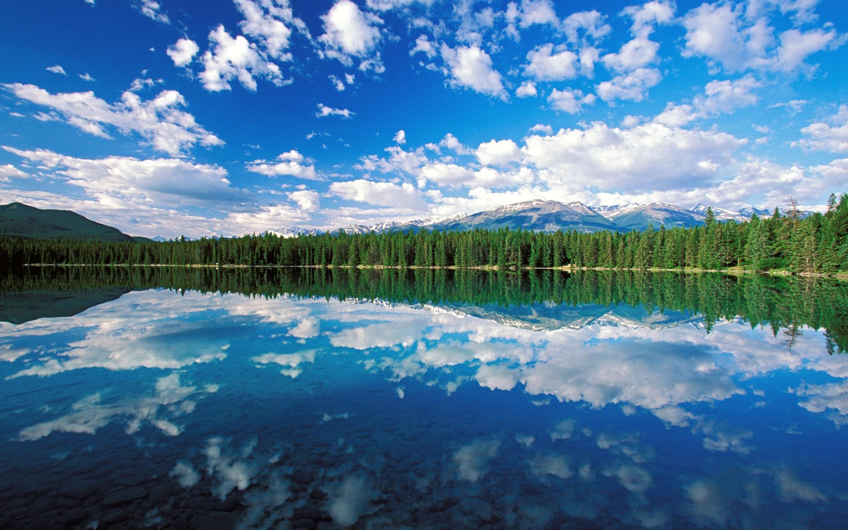 Облака отражаются в озере в национальном парке Джаспер, Канада 