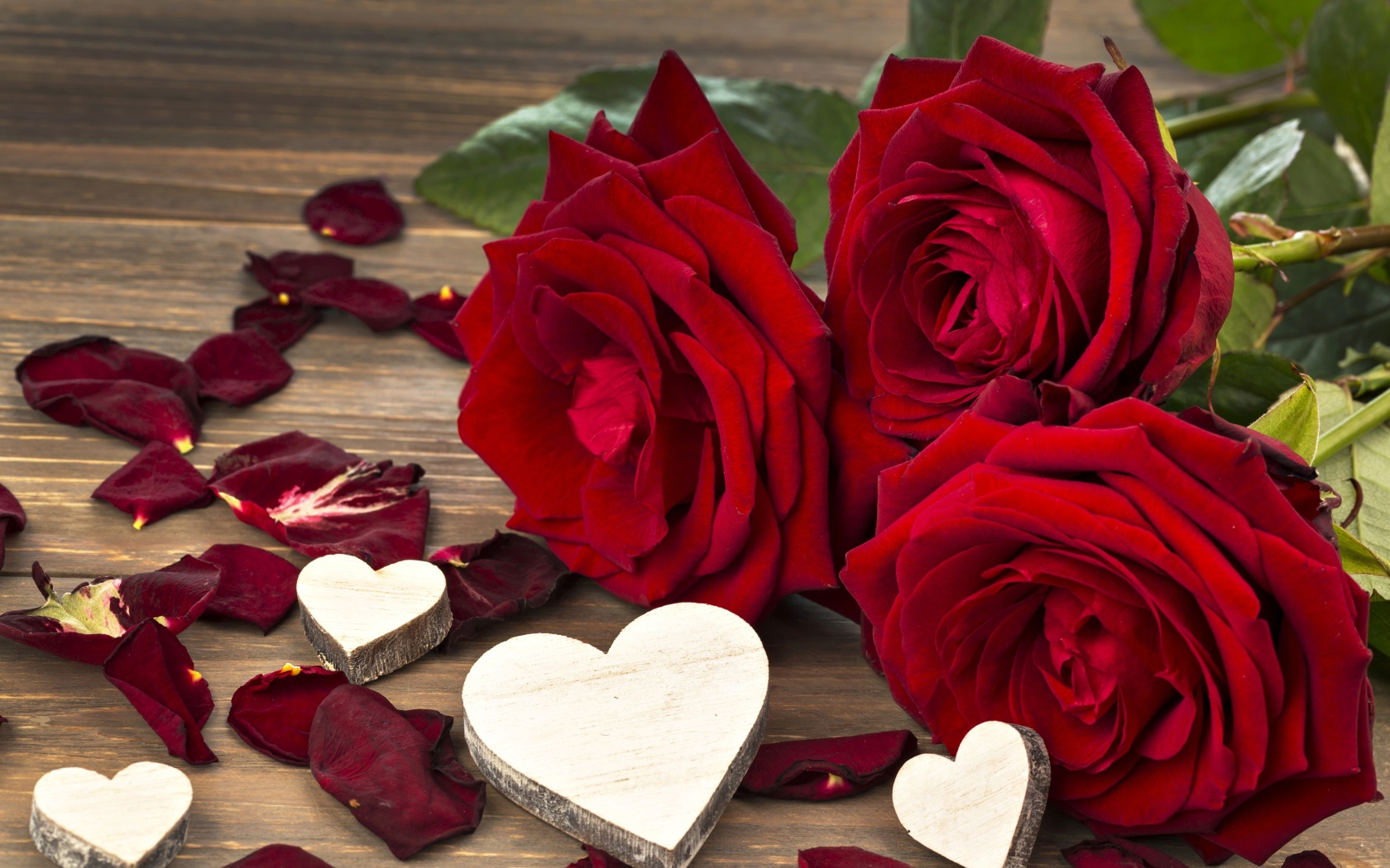 Три крупные красные розы с деревянными сердечками
