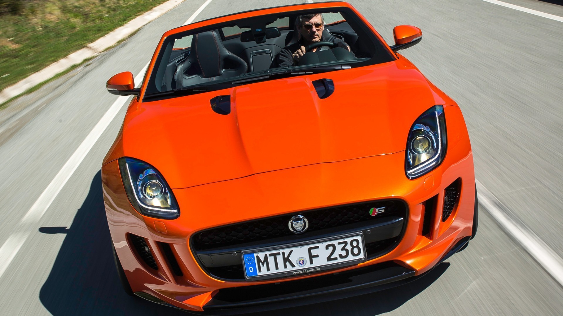 Оранжевый Jaguar F-Type на шоссе