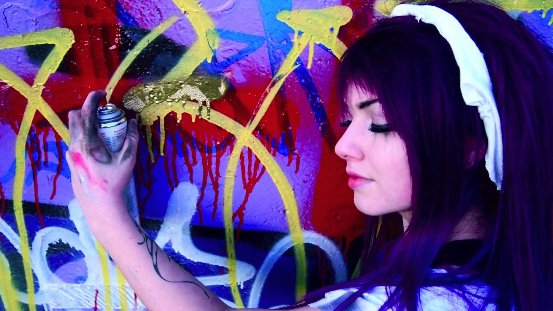 Девушка рисует граффити на стене