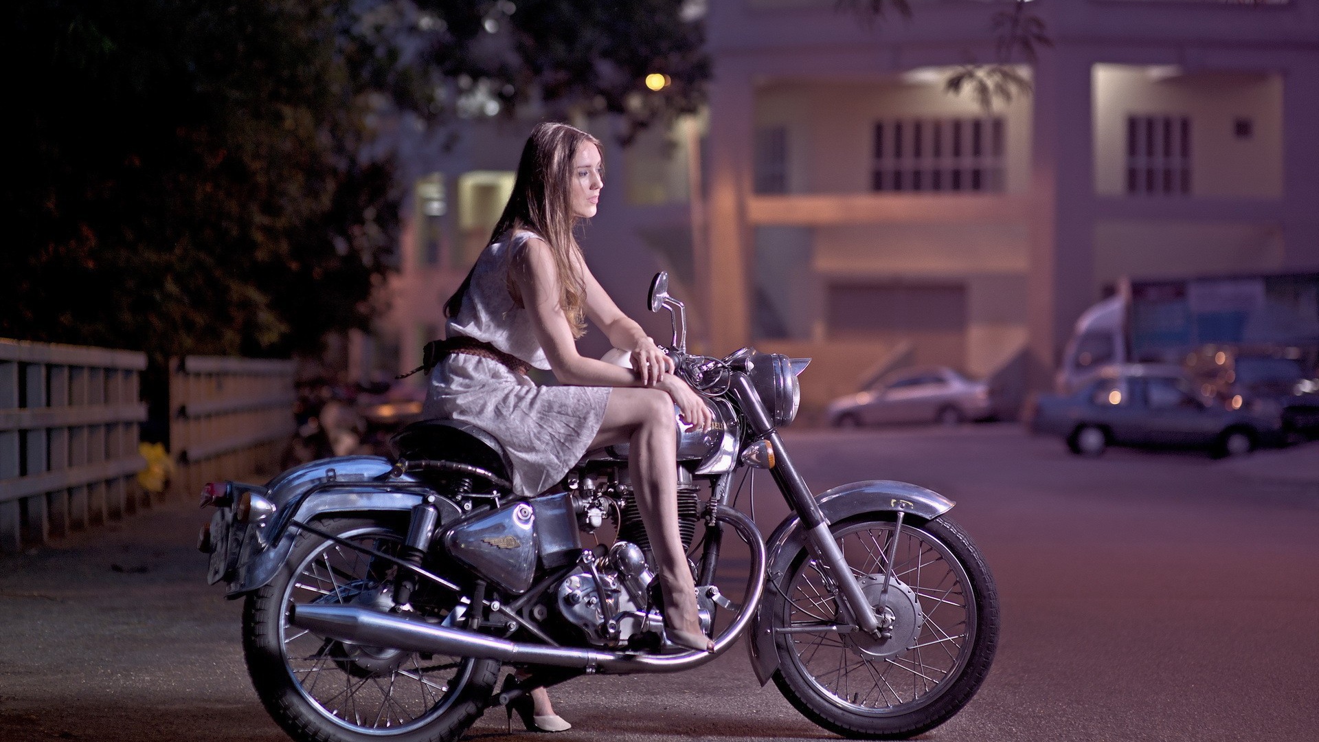 Девушка на мотоцикле стоит на парковке