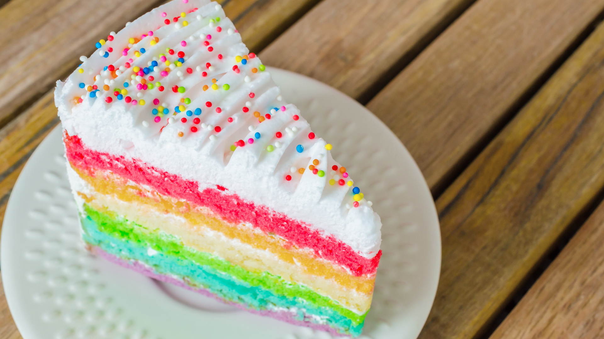 Кусок разноцветного торта на белой тарелке