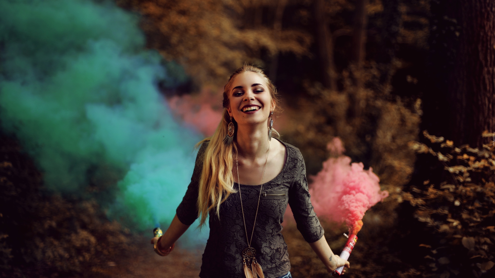 Красивая улыбающаяся девушка с дымовыми шашками в руках