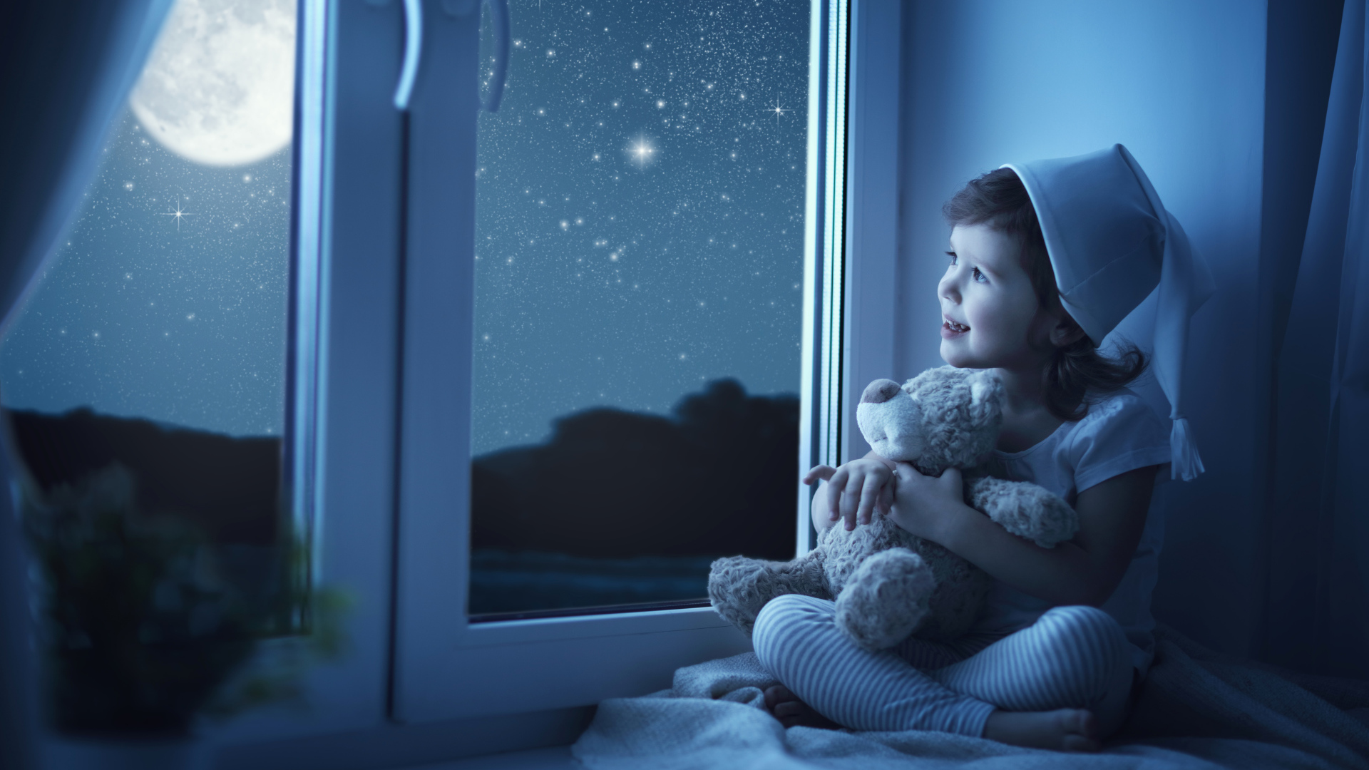 Маленькая девочка сидит на подоконнике с игрушкой ночью