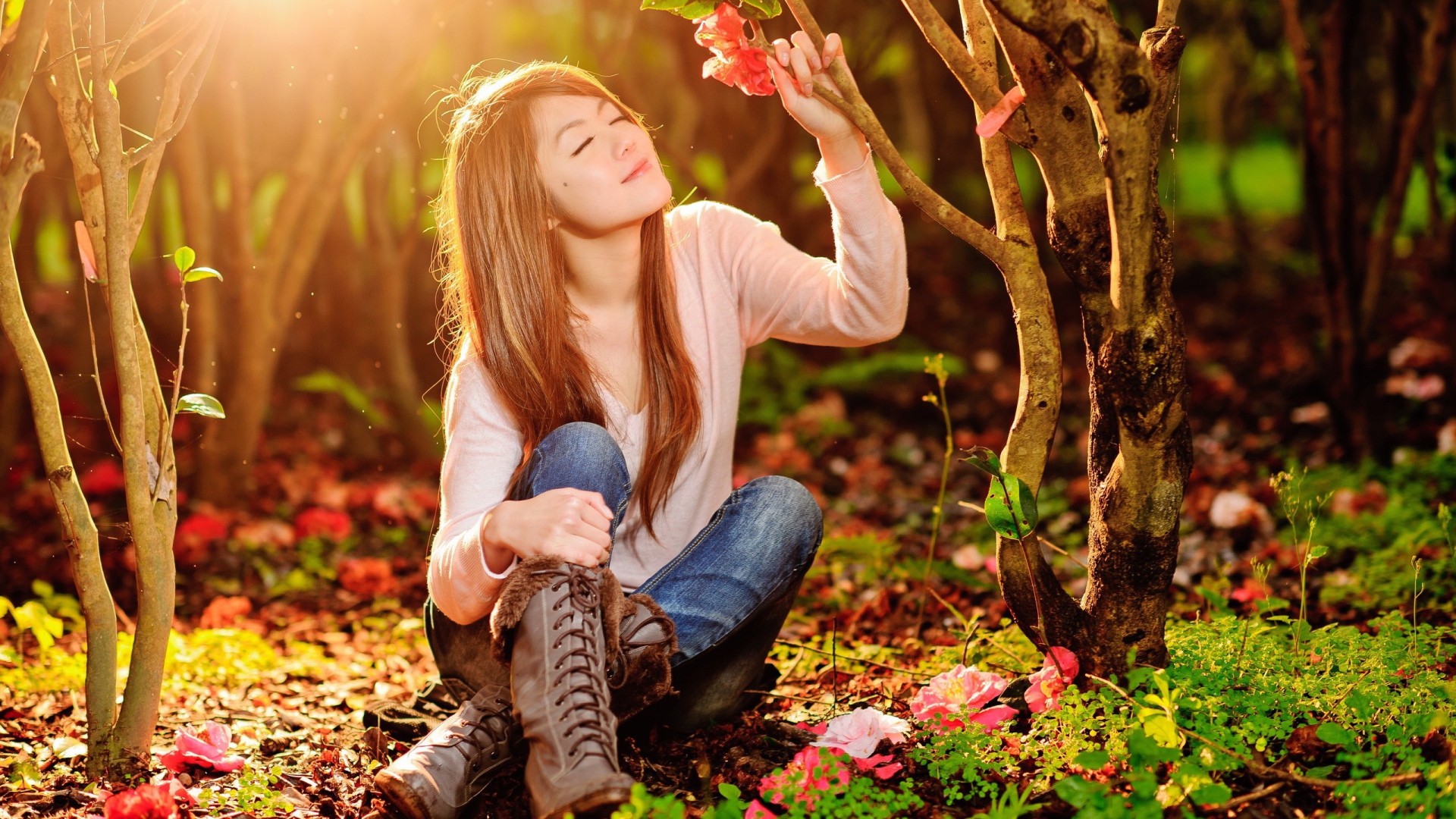 A girl sits on the ground under a bright sun in the forest