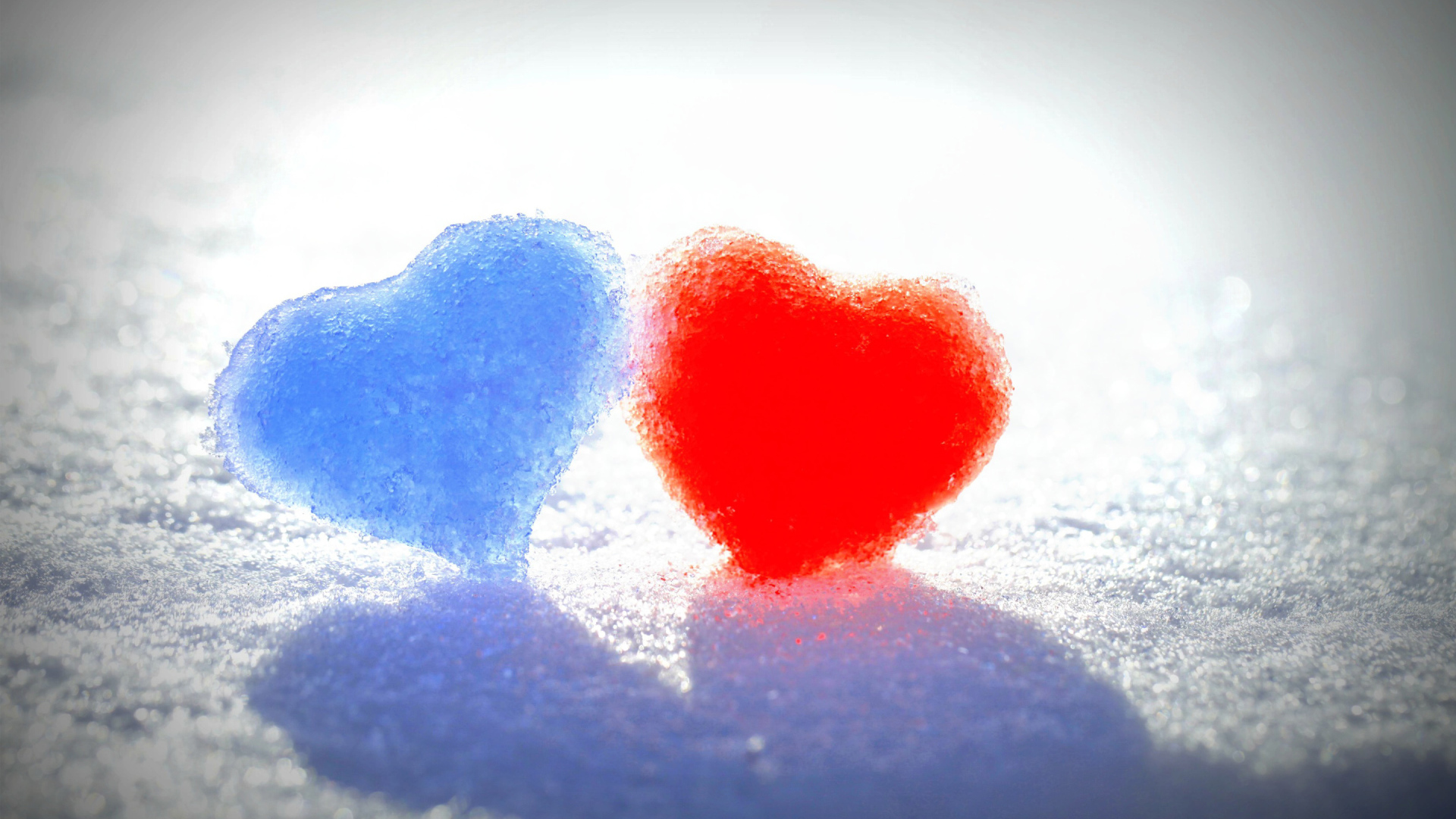 Голубое и красное сердце на белом снегу 