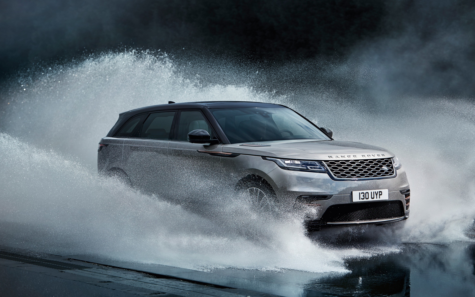 Серый автомобиль Range Rover Velar, 2017 проезжает по воде