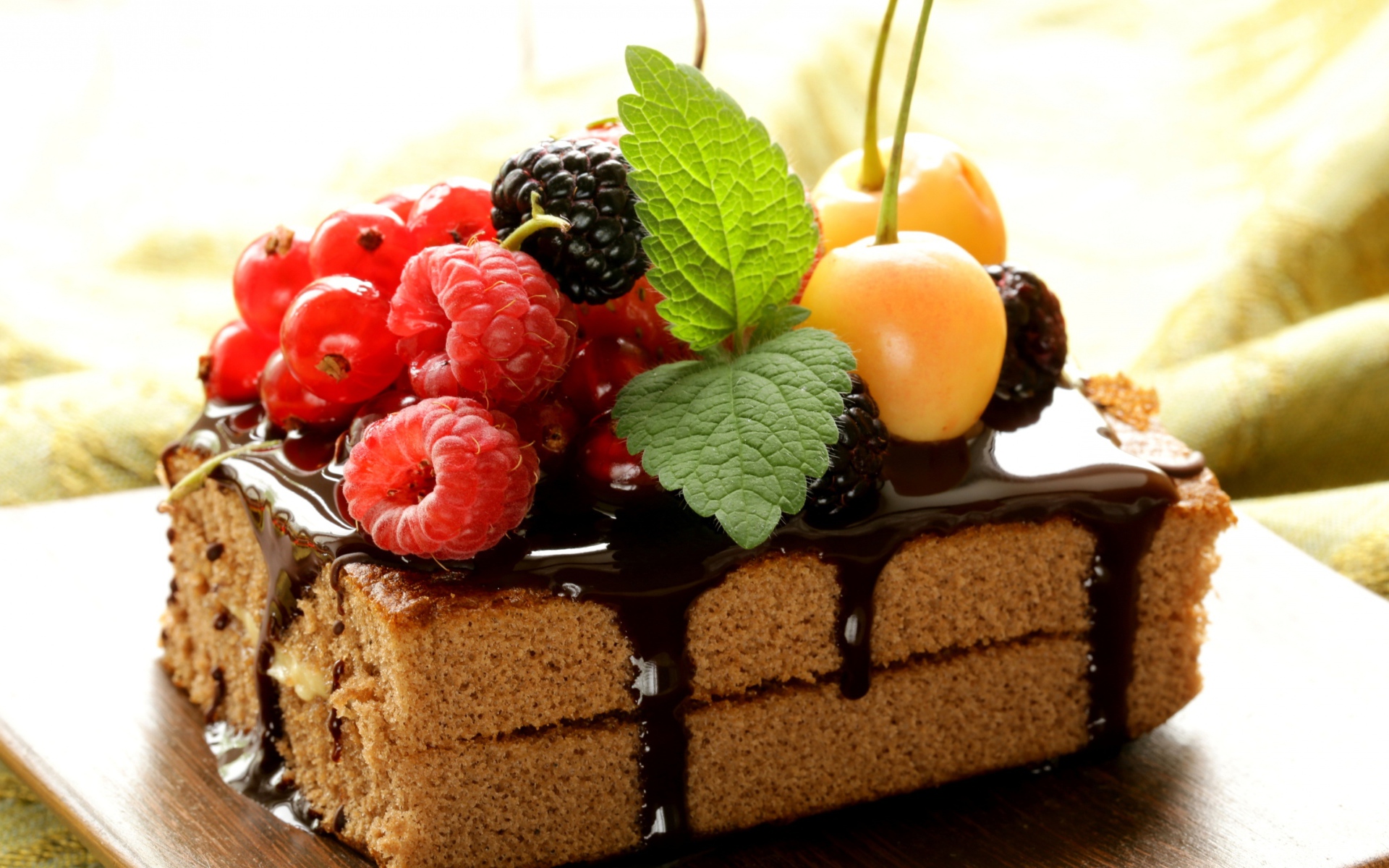 A piece of cake with chocolate and fresh berries