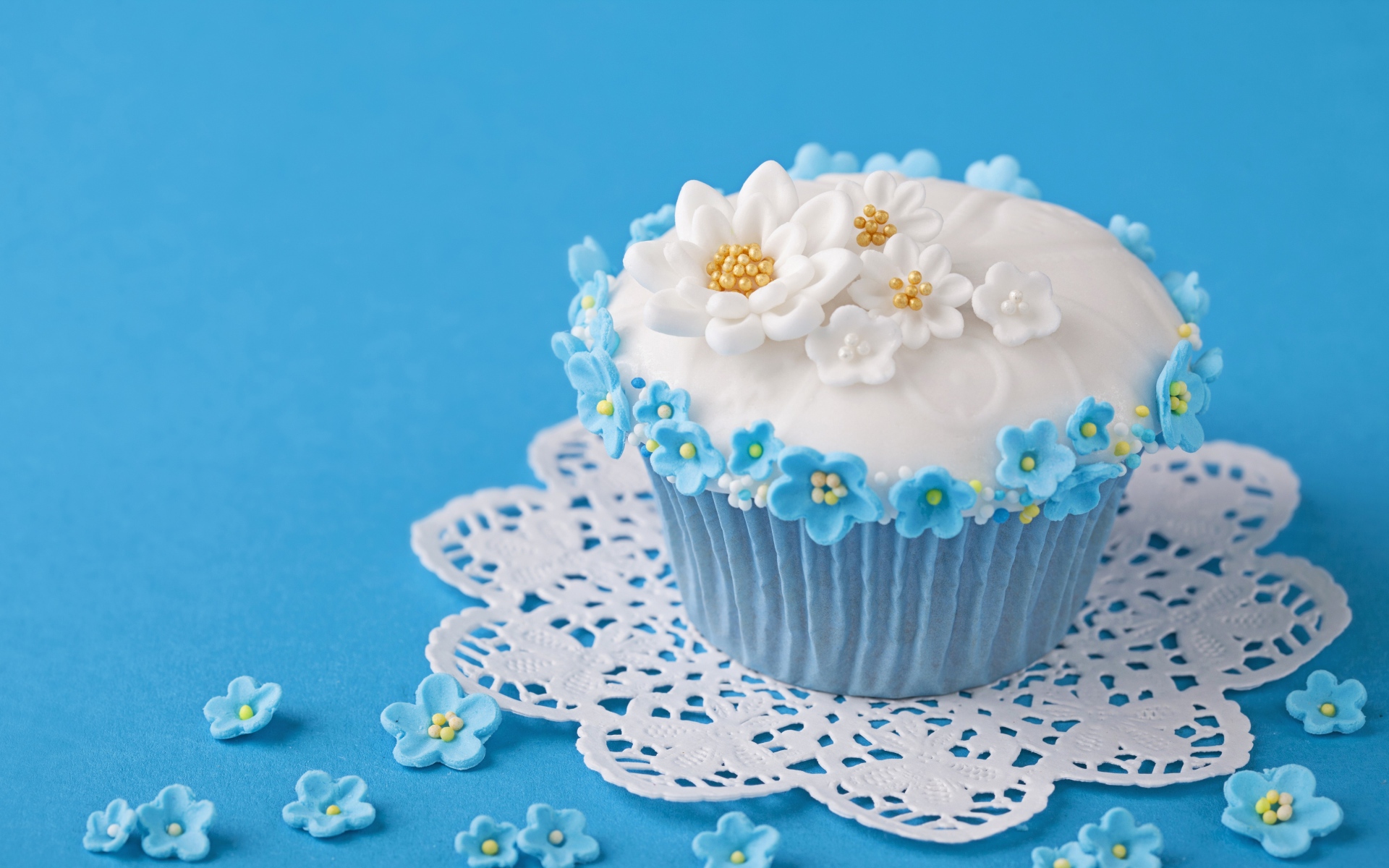 Аппетитный кекс украшен цветами на голубом фоне