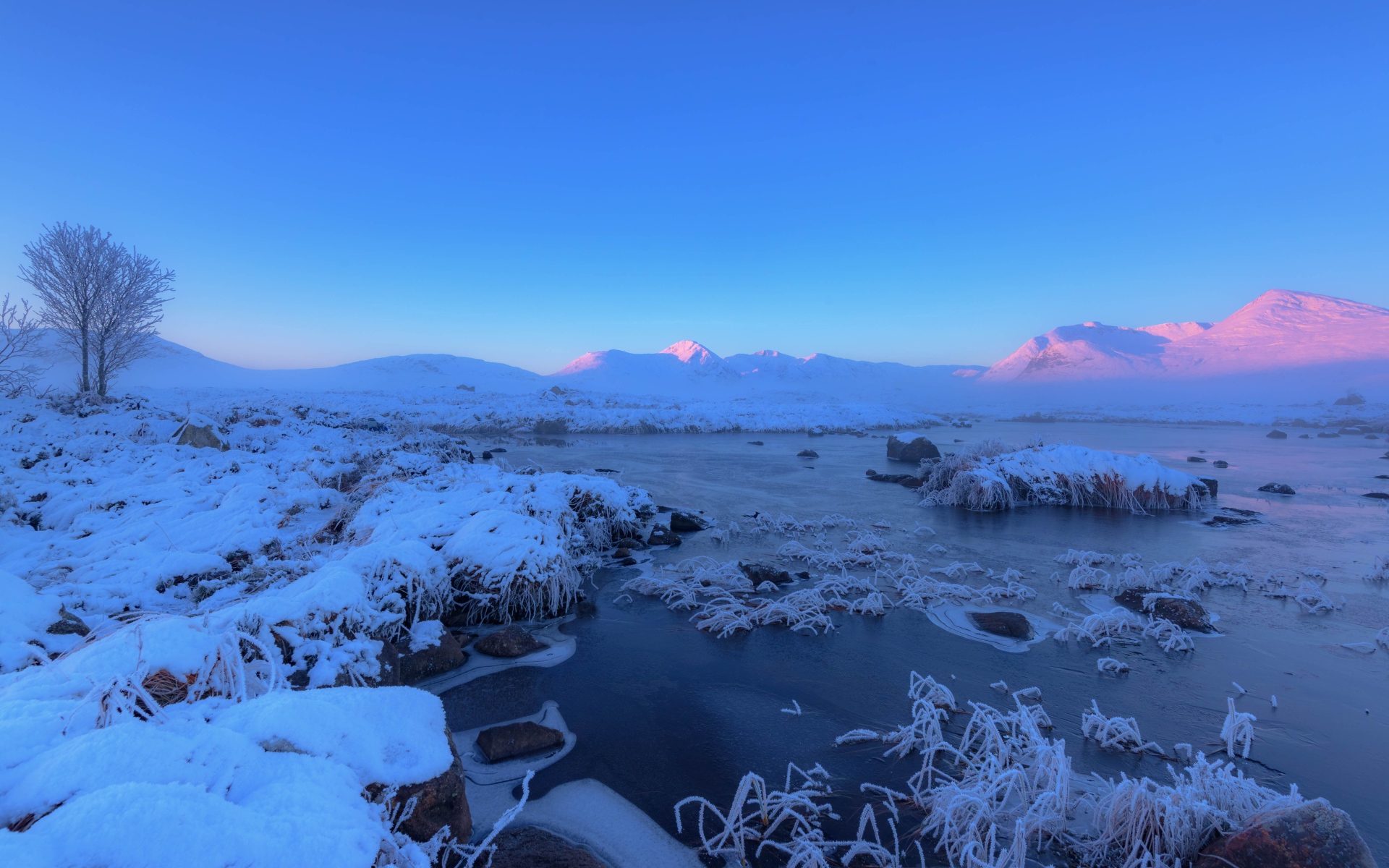 Розовый закат солнца над заснеженными горами и покрытым льдом озером