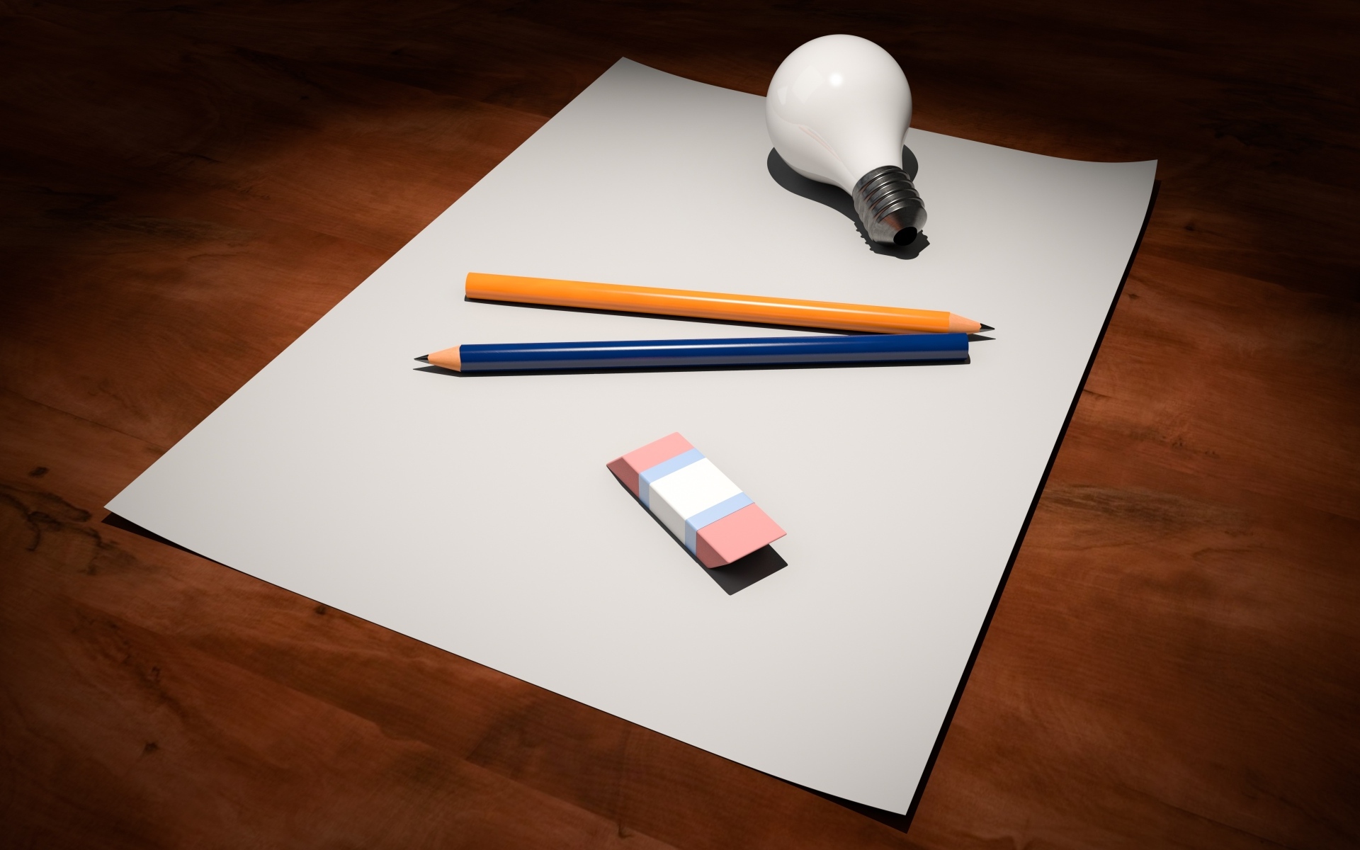 Лист бумаги, карандаши, ластик и лампочка на столе