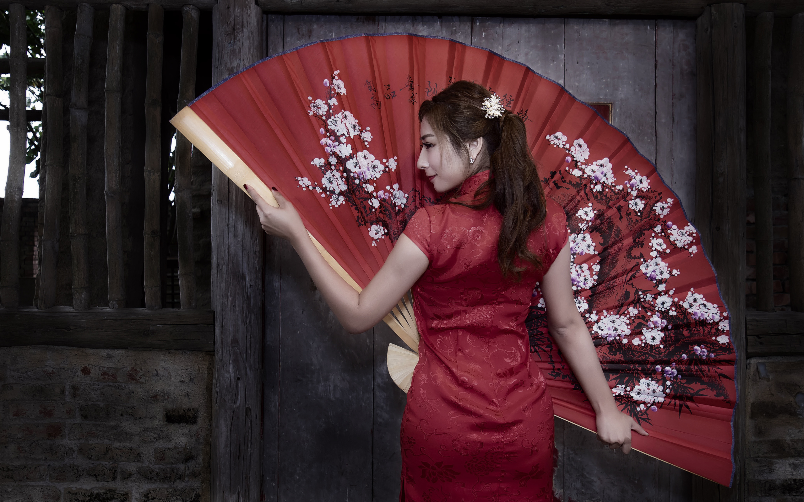 Beautiful asian girl in red dress with big fan