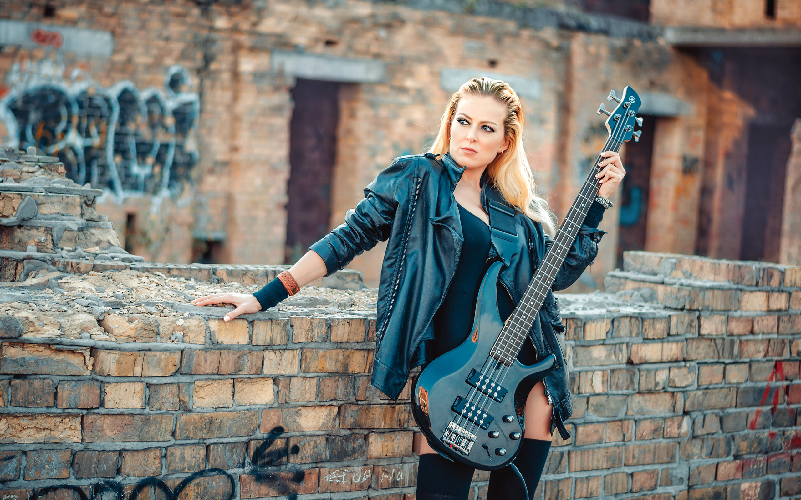 Blonde in a leather jacket with an electric guitar in her hands