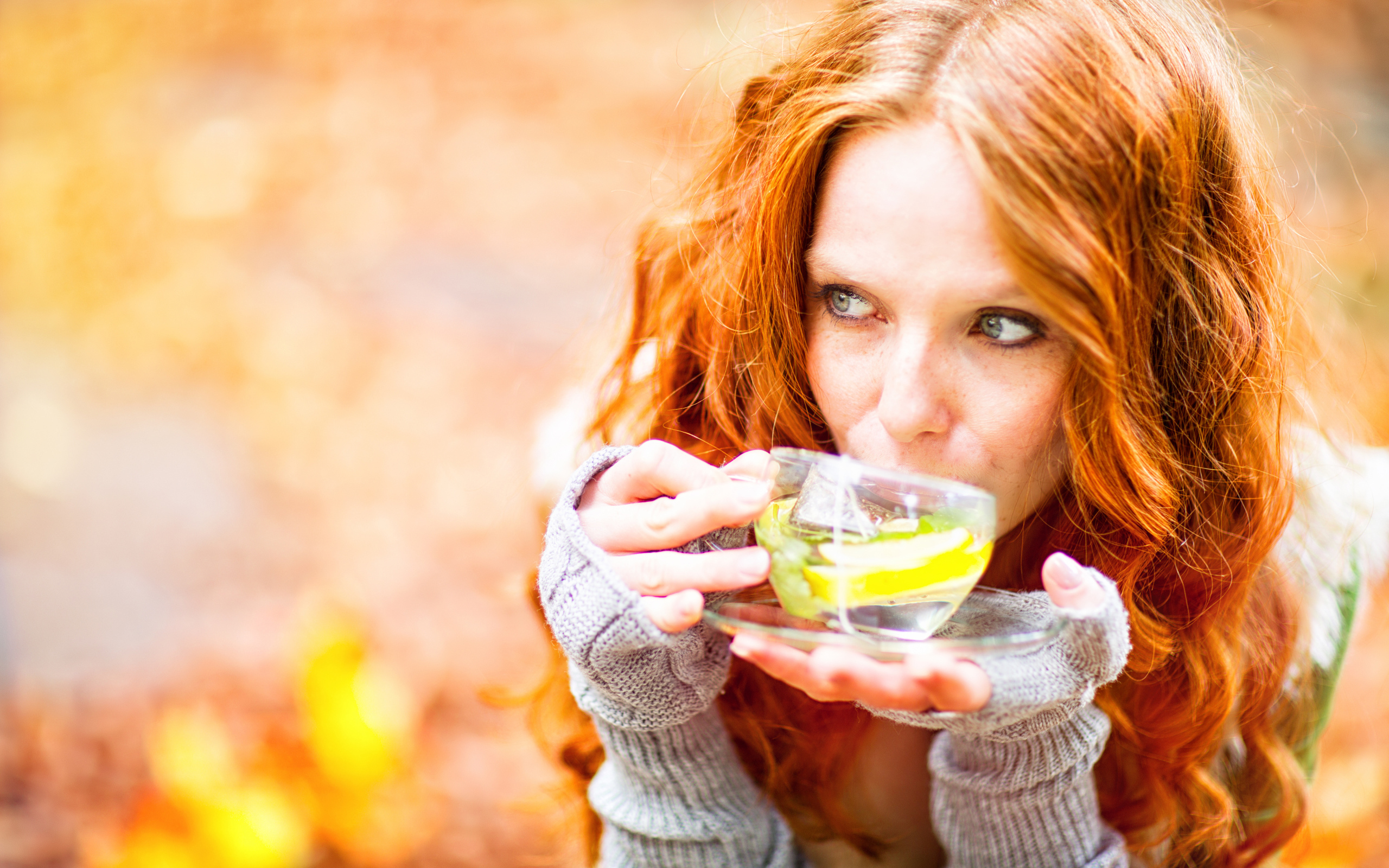 Red-haired girl model with a cup of green tea