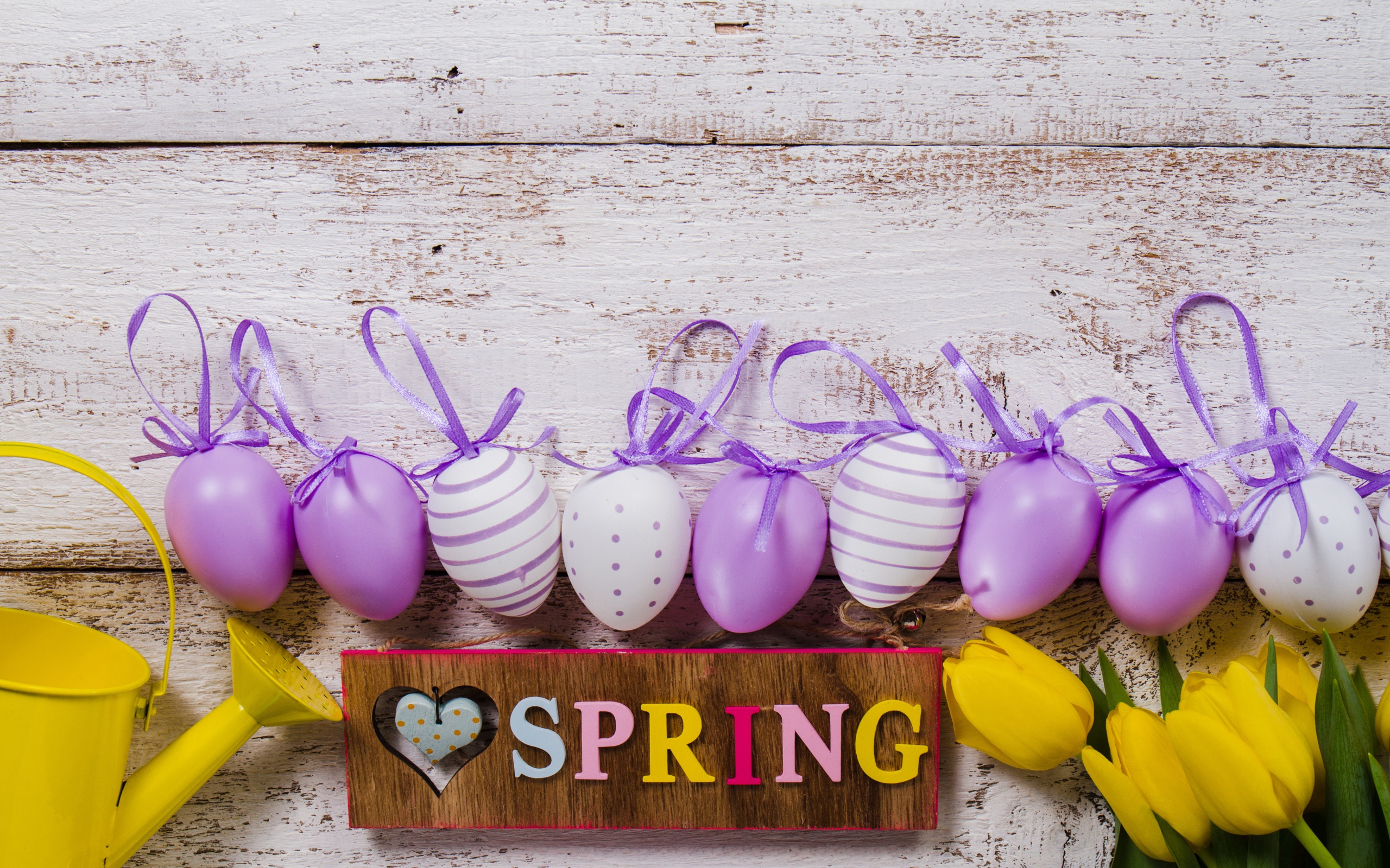 Разноцветные яйца, букет тюльпанов и надпись весна на деревянном фоне
