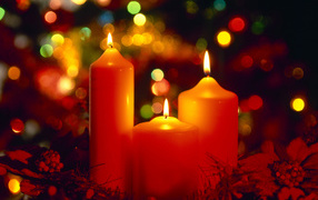 Горящие красные свечи на фоне гирлянды на рождество