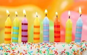 The colorful candles on the birthday cake