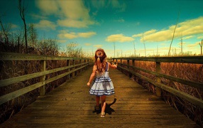 A girl goes on a wooden bridge