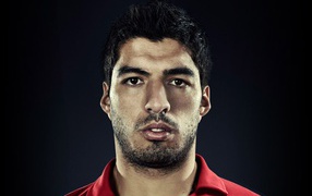 The football player of Liverpool Luis Suarez on the black background