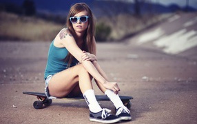  The girl with skateboard and wearing glasses