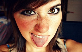 Girl with freckles showing tongue