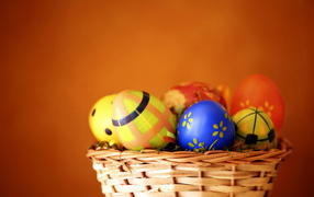 Basket of eggs on orange background for Easter