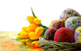 Basket of eggs on the background of tulips for Easter
