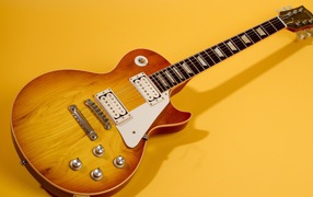 Guitar with shadow on a yellow background